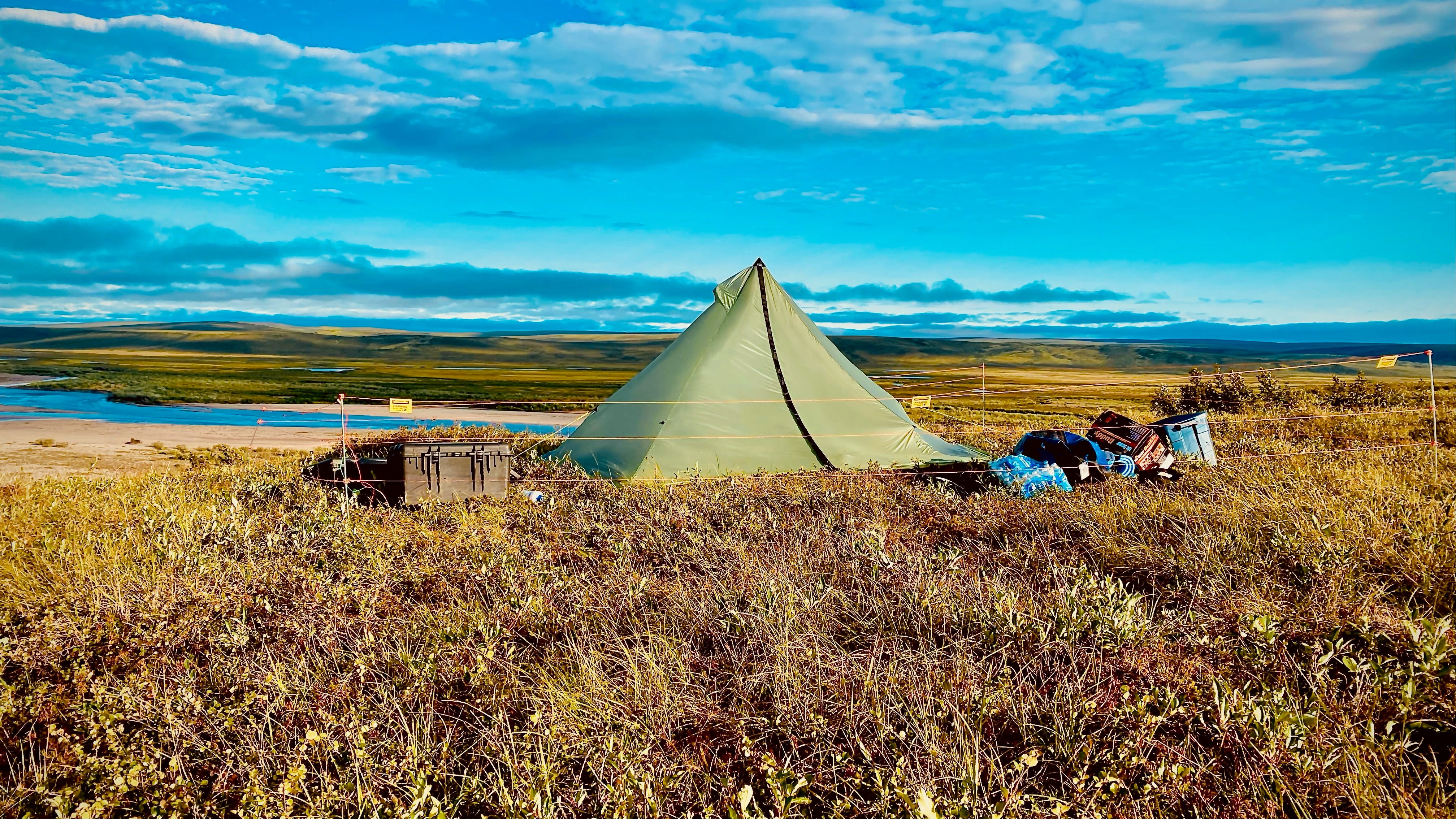 Portable electric bear fence set up around tent in Alaska