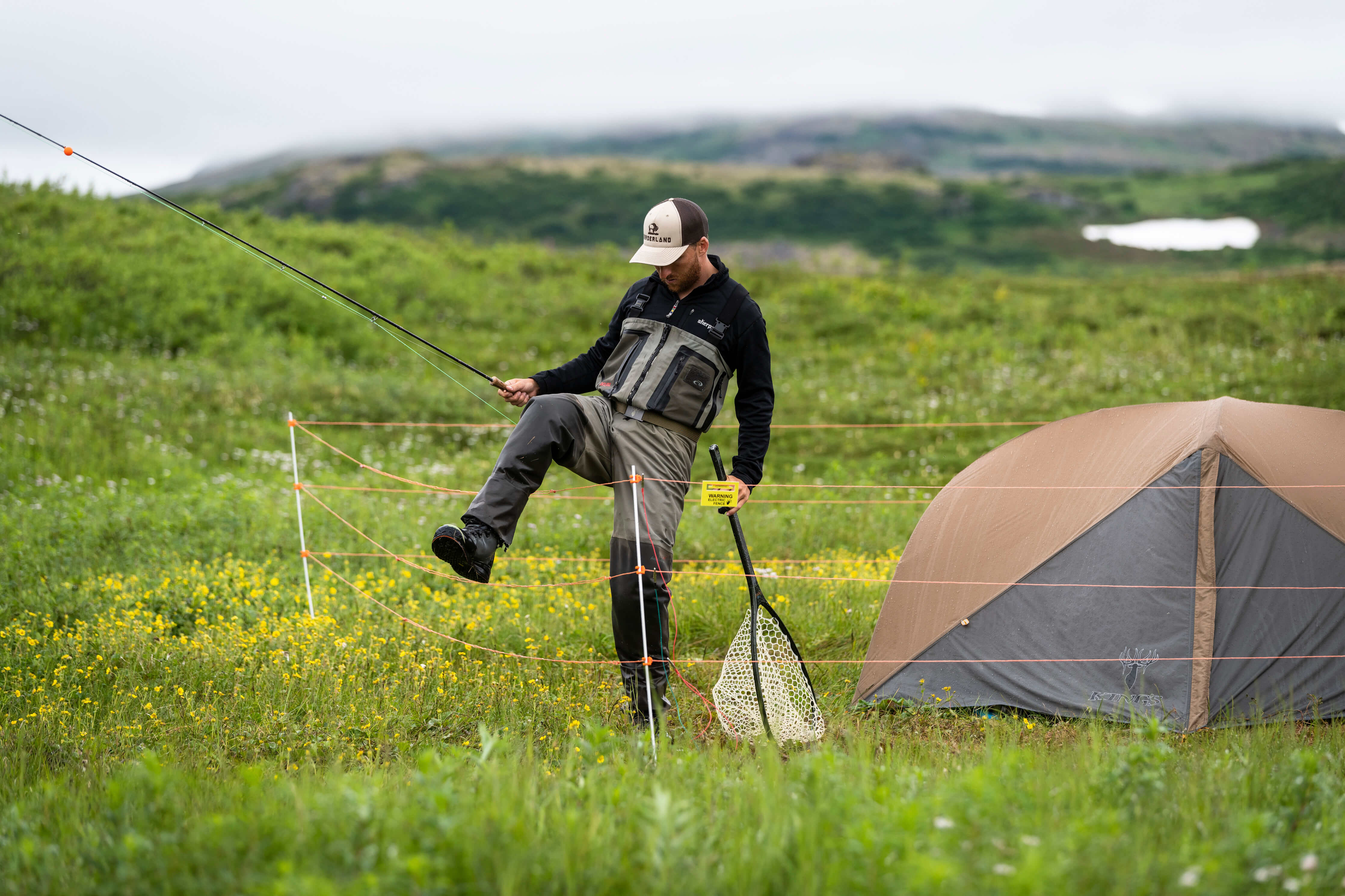 Fisherman Hunter protecting his camp with portable electric fence in Alaska